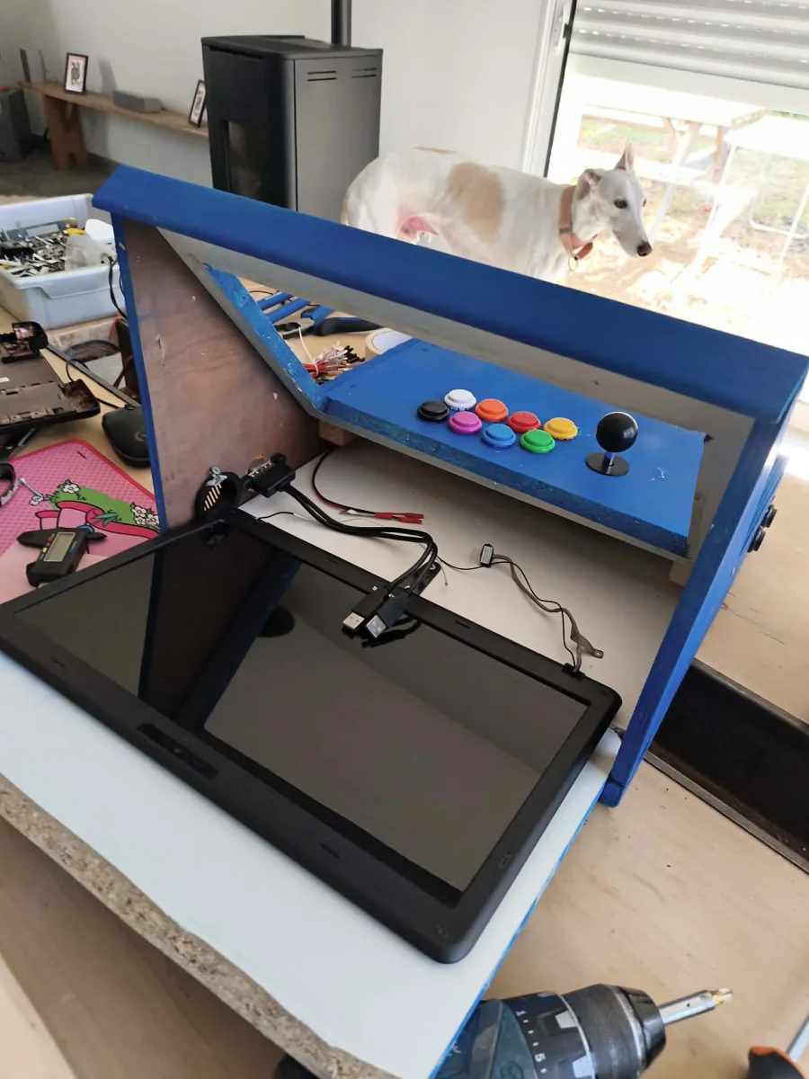 La borne d'arcade en bois terminée, peinte en bleu et équipée d'un joystick et de boutons colorés
